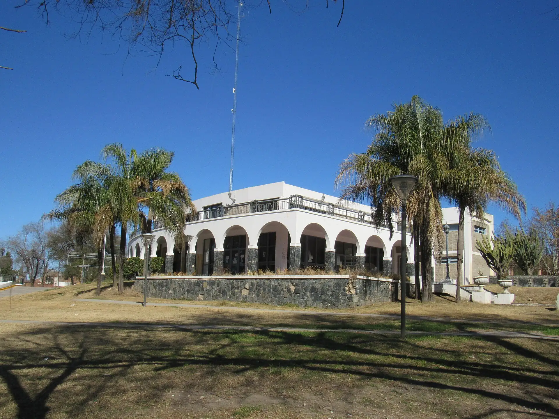 Alta Gracia bus terminal with arches and palm trees