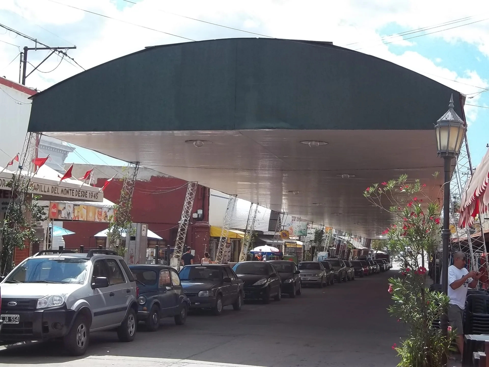 Shops and parked cars beneath Calle Techada in Capilla del Monte