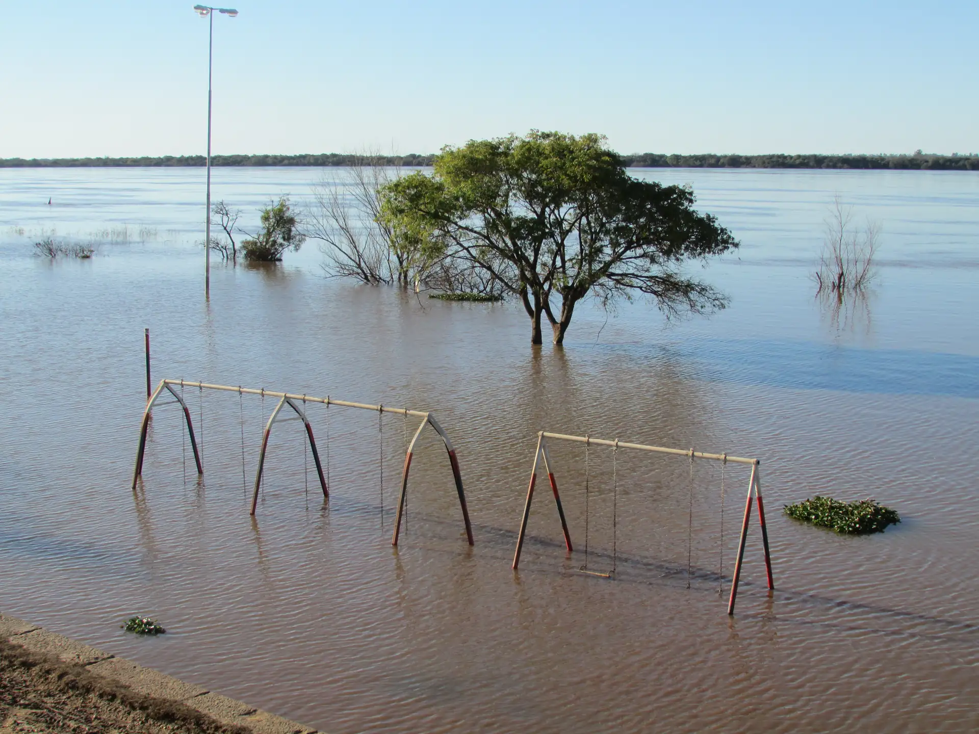 Floodwater beside trees and riverfront play equipment in Colón in 2014
