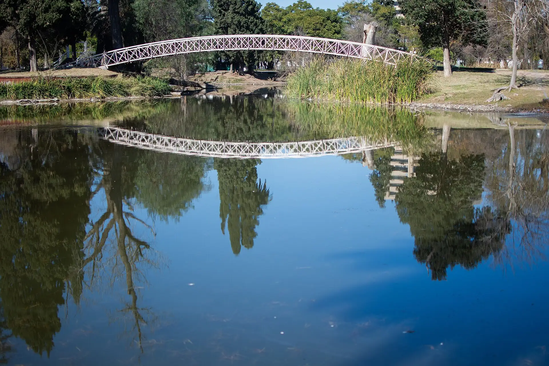 A footbridge reflected in the lake at Parque Sarmiento, Córdoba, Argentina