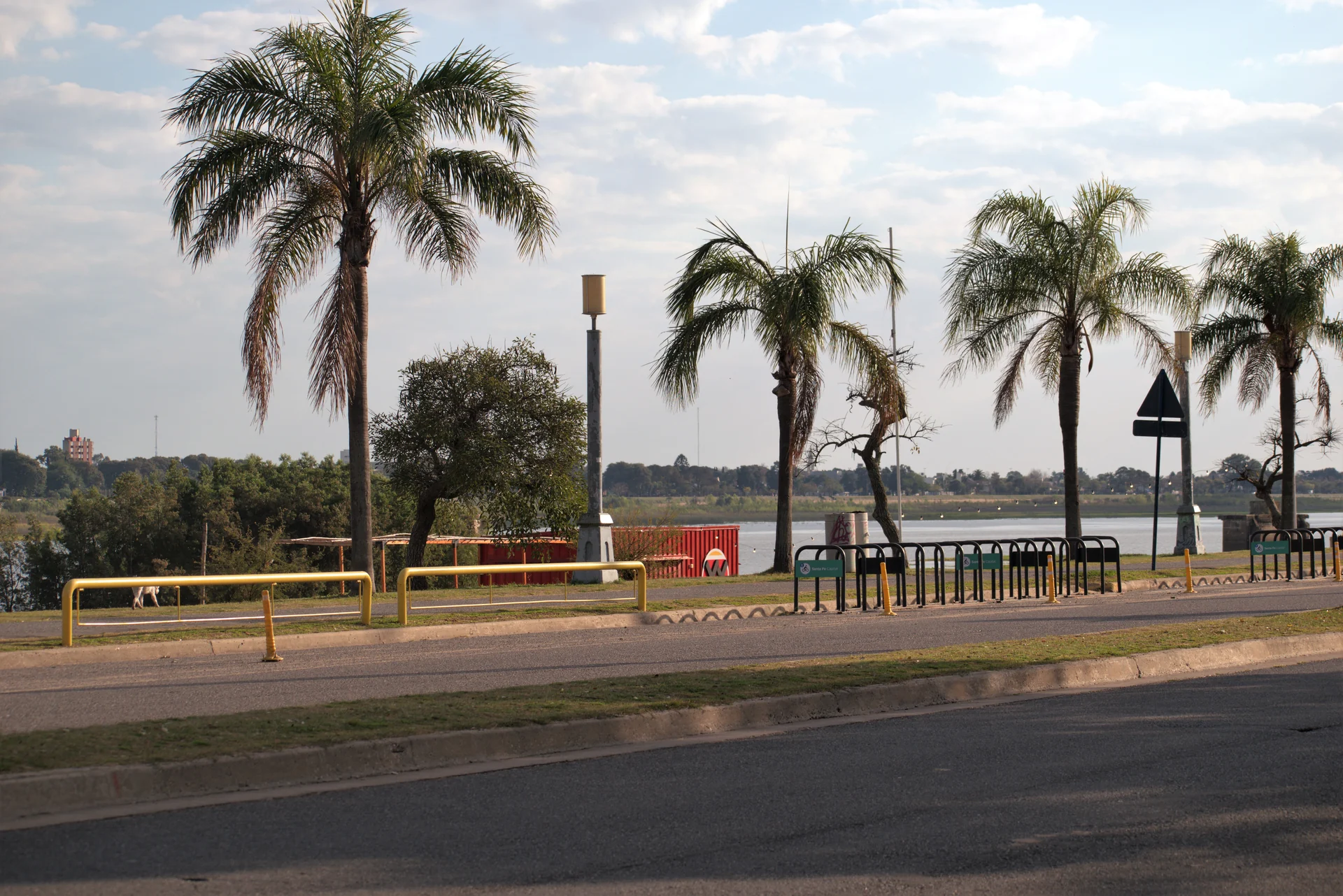 Palm trees, a road and waterfront railings at Costanera Este in Santa Fe in August 2022
