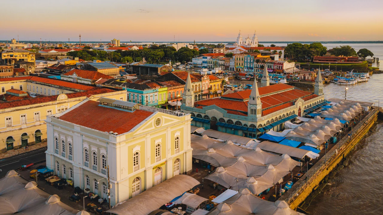 Historic Belém market roofs, white towers, river boats and waterfront in late-afternoon light