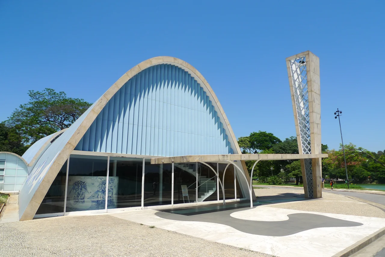 The curved São Francisco de Assis church under a blue sky at Pampulha