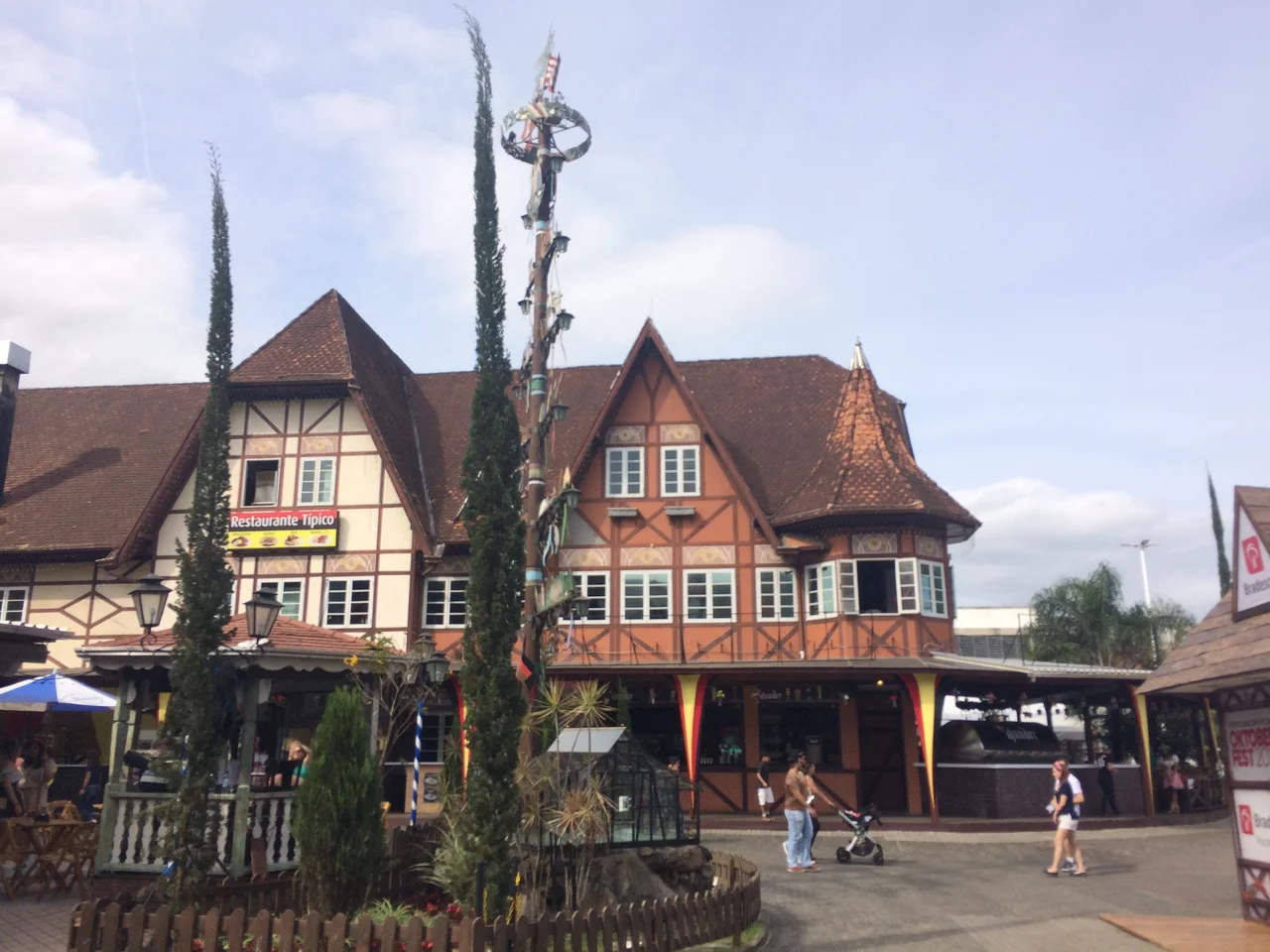 Half-timbered Vila Germânica buildings, trees and a decorated pole in Blumenau