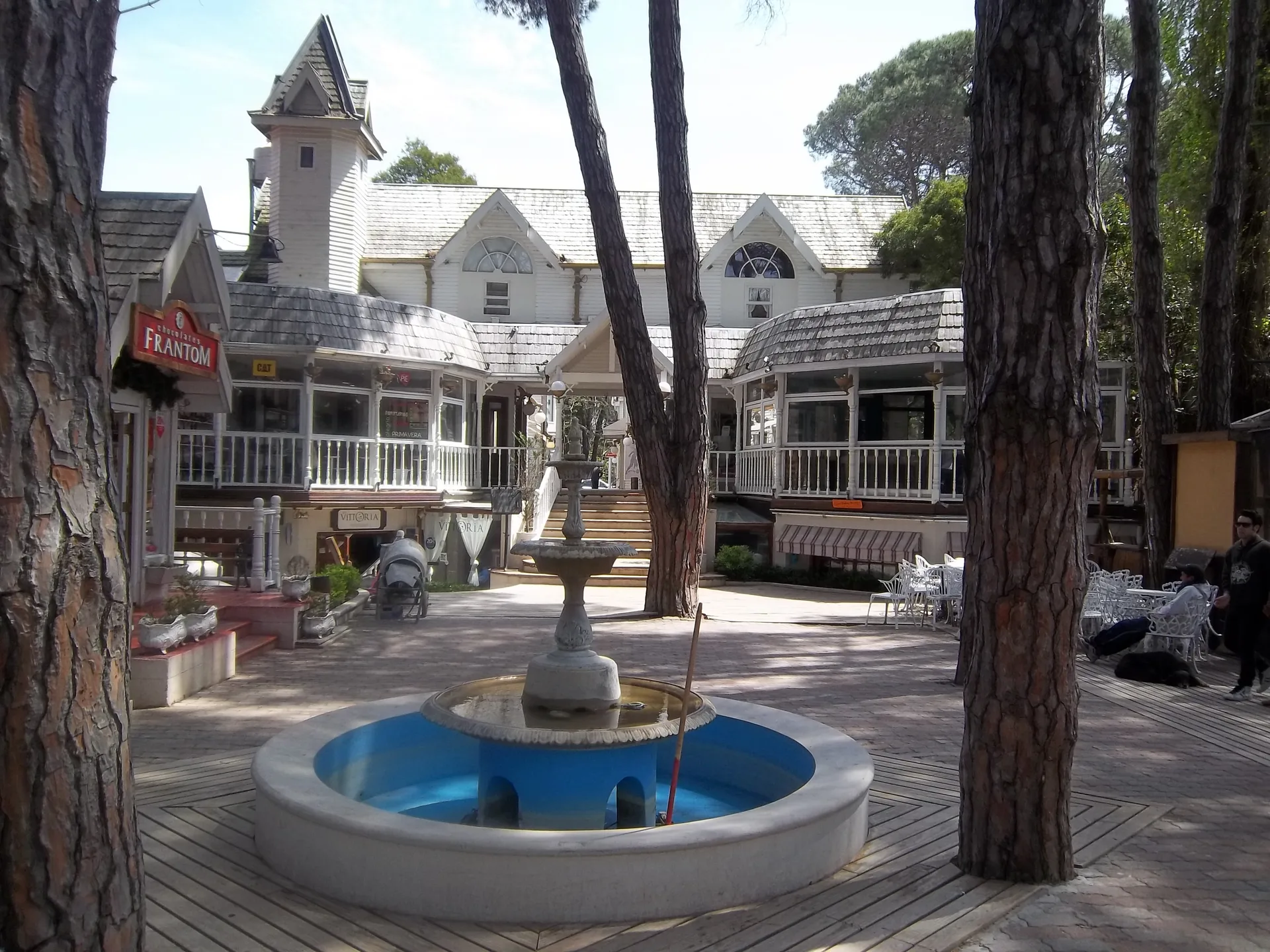 Fountain, trees and shops in Cariló commercial center