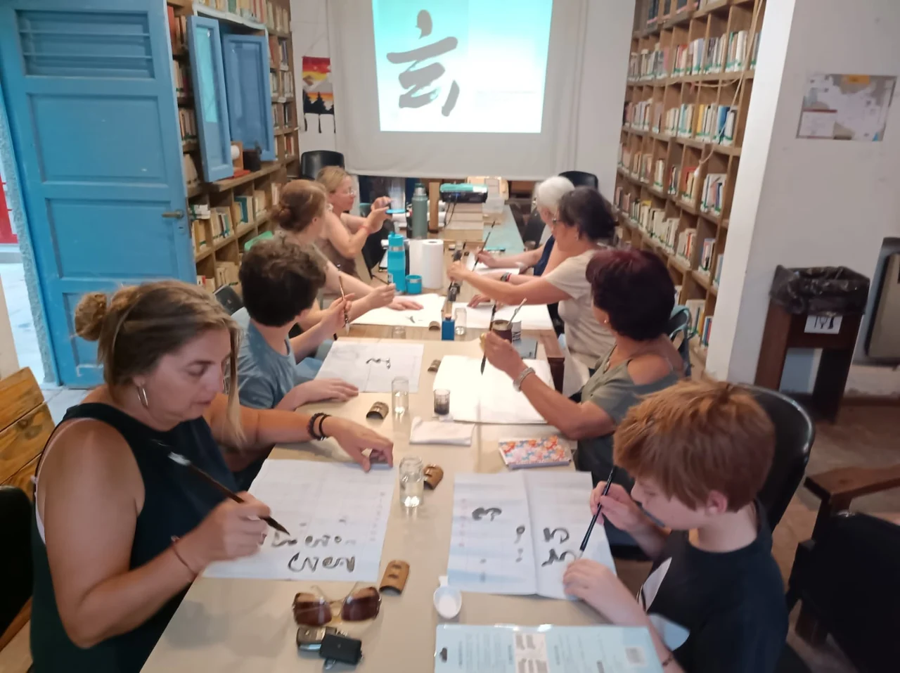 People practicing Japanese calligraphy at the Chacras de Coria community library