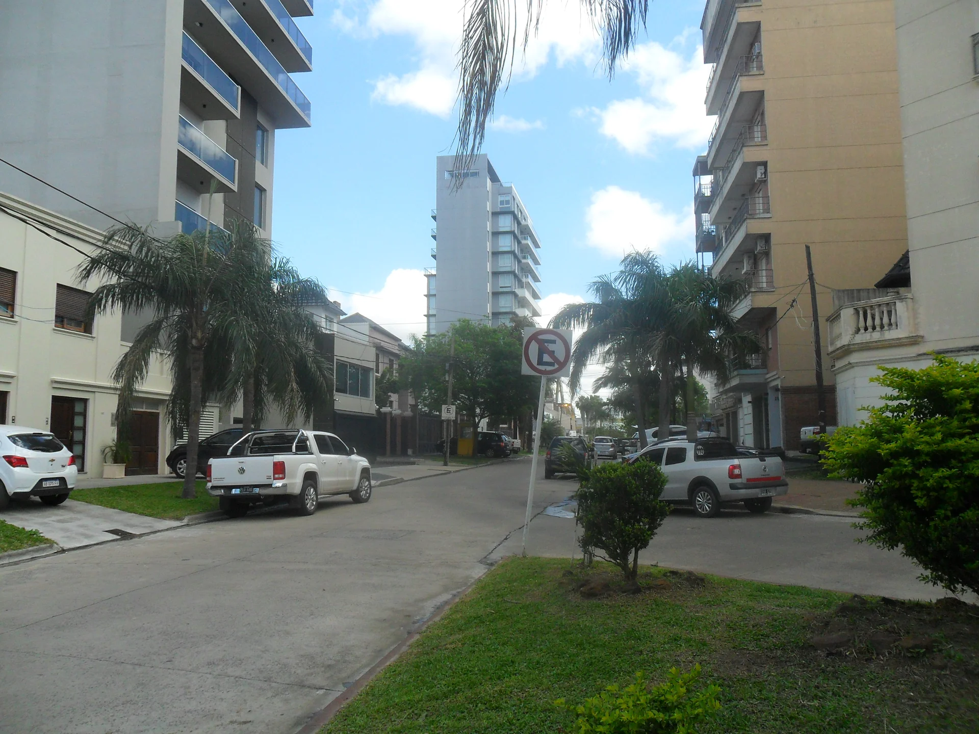 Pasaje Quevedo in Corrientes, with apartment buildings, parked vehicles and palm trees