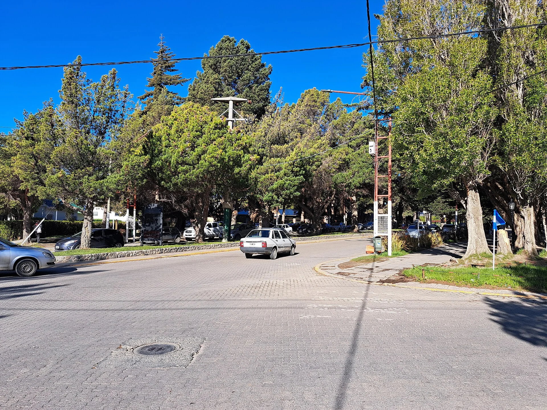 Avenida del Libertador with trees, vehicles and a sidewalk in El Calafate