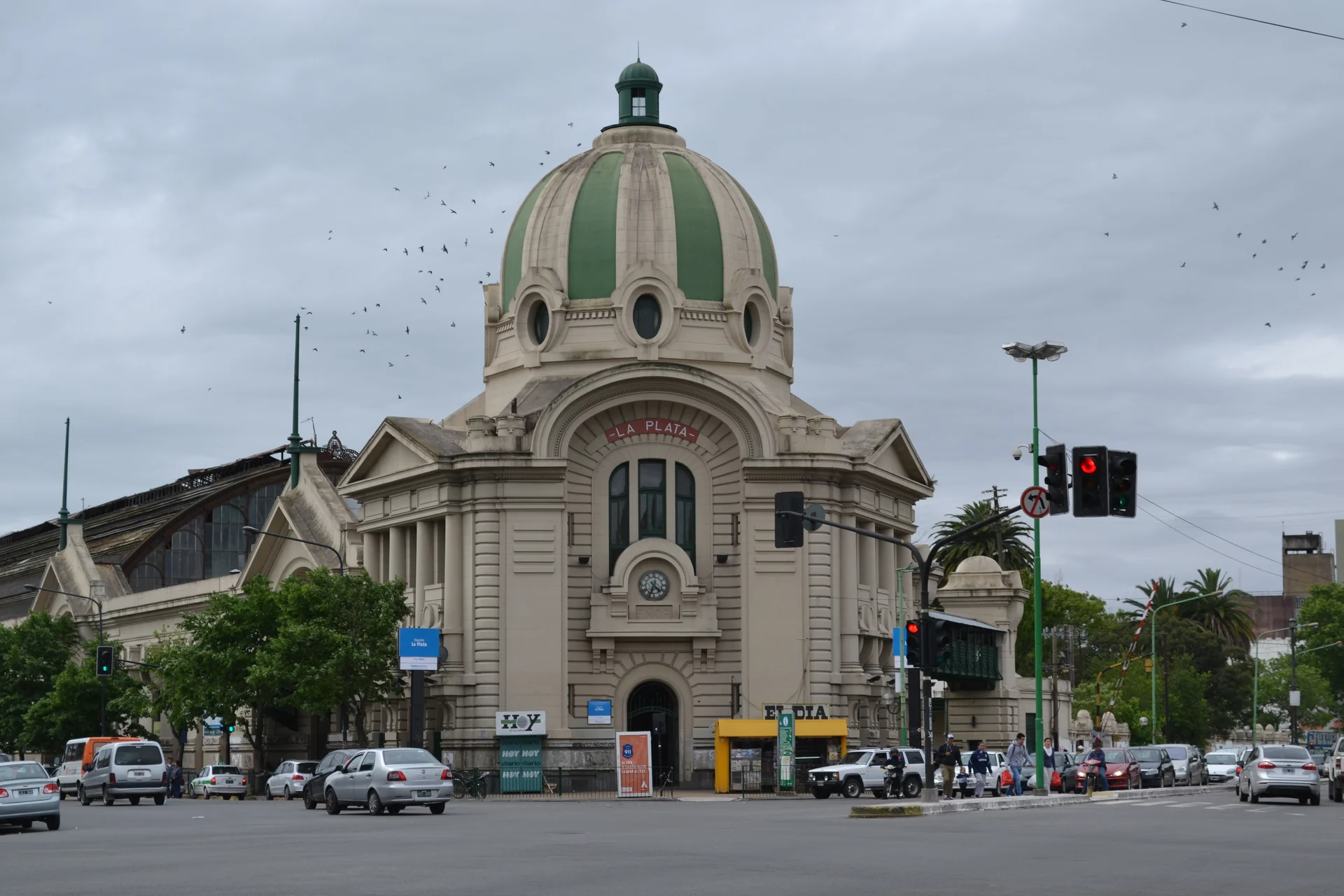 The La Plata station entrance and green dome, with people and street traffic