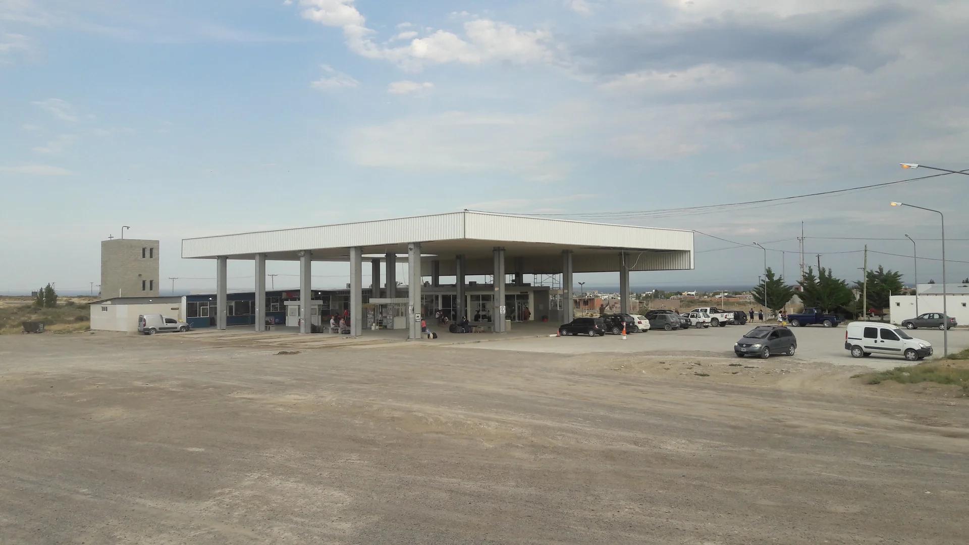 The broad canopy and entrance of Las Grutas bus terminal, with parked vehicles