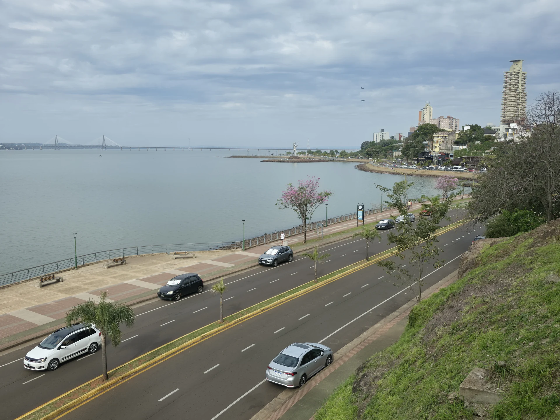 An elevated view of the Posadas Costanera beside the Paraná River, with roads, paths and the bridge in the distance