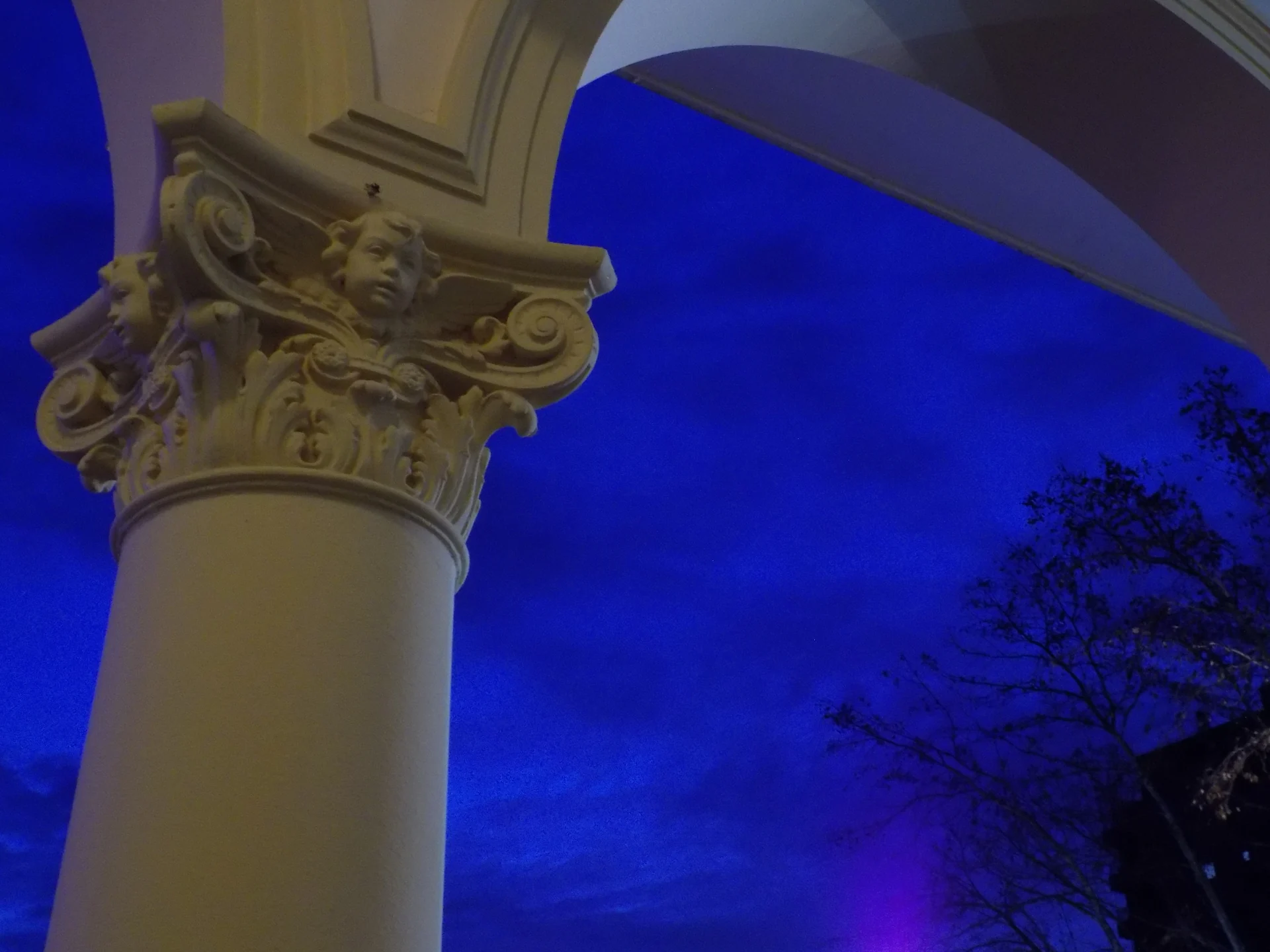 A decorative column capital and arch at Quilmes Cathedral against a deep blue evening sky