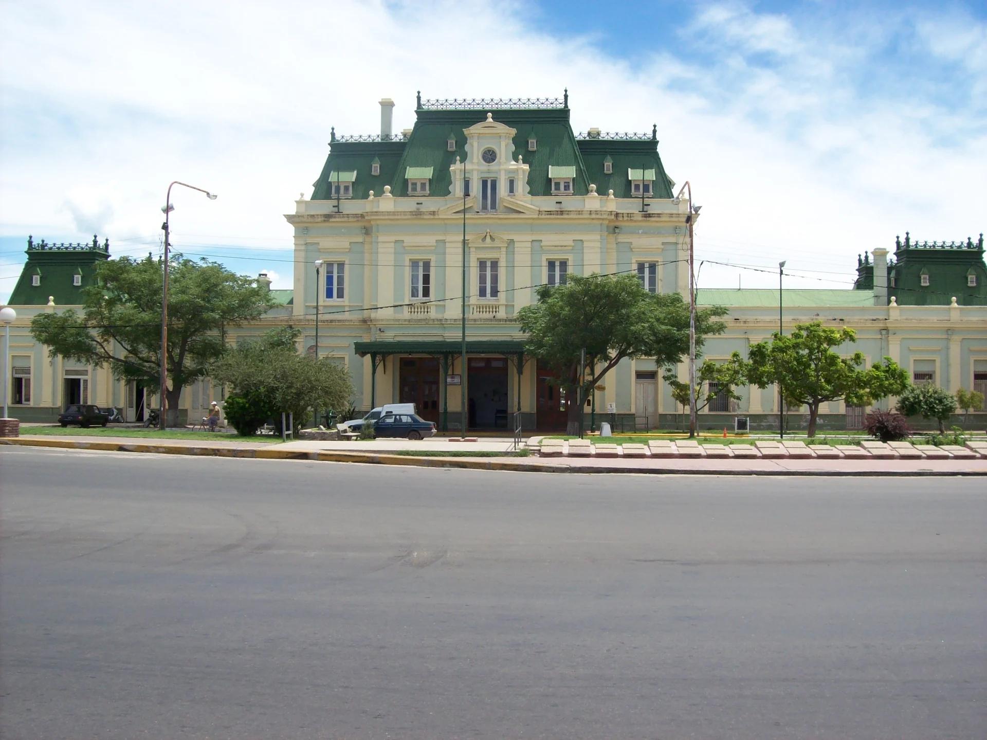 The pale facade and green roof of the former railway station in San Luis